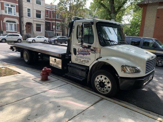 A picture of parties tow truck come apart in front of a fire plug for hours now.