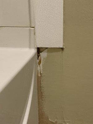 Hole in wall, unfinished patch, unsealed near tub