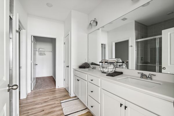 Primary bathroom with double vanity and large walk-in closet.