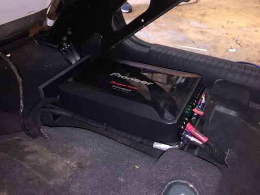 A Pioneer stealth amp installed under the front seat of a Jeep Liberty