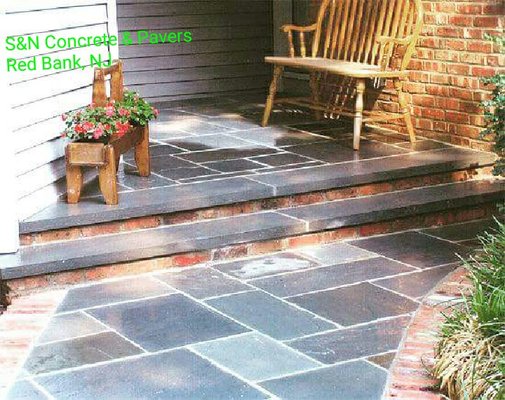 Bluestone walkway with a used brick border. Used brick steps with a sharp blustone tread smd irregular rectangle bluestone pad.