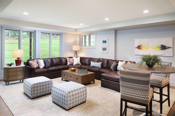 Custom pillows in fabrics from STARK, Old World Weavers and Vanguard create visual interest on the large Kravet faux-leather sofa.