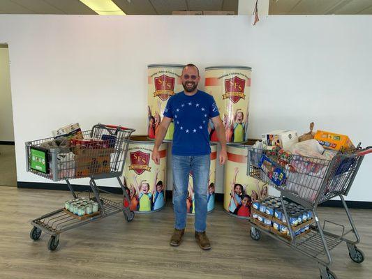 Executive Director Tim White receives food drive donations collected by the Greater Pan-Helenic Council of Fredericksburg.