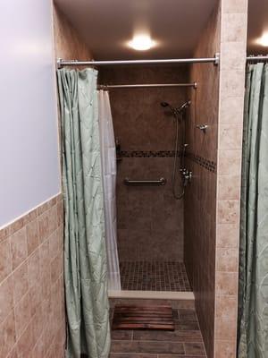 Tiled showers, including shower head and hand-held shower.