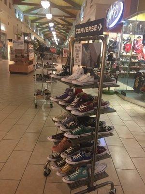 Racks of shoes out in the mall.