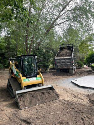 Bobcat and truck used in earthmoving work