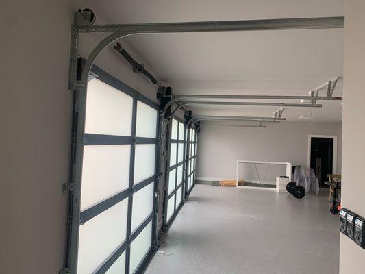 INSIDE GARAGE, FULL VIEW DOORS INSTALLED ALONG WITH LIFTMASTER JACK SHAFT OPERATORS