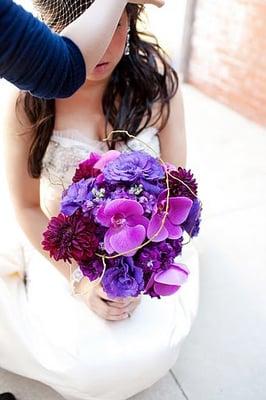 Bride's bouquet of dark purple stock, burgundy dahlias, purple lisianthus, magenta phalenopsis orchids, and curly willow