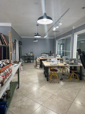 Clean and open store with tables for sewing classes and other classes offered at the Needles Studio in Los Altos.  Julie A