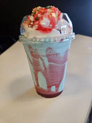 Blue moon shake with fruity pebbles and strawberry drizzle. Topped with whipped cream and nerds.