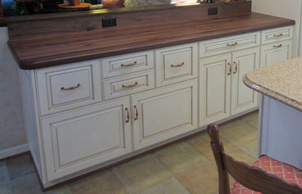 White cabinets w/glazing, a walnut counter, & copper pulls and light fixtures.  Beautiful!