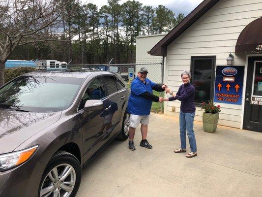 Donny Whitaker is handing Janice the keys to her newly repaired (and cleaned!) car.