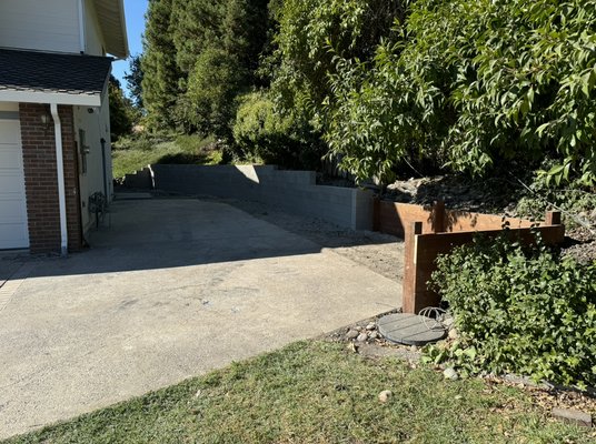 Cinder block retaining wall with a small Redwood retaining wall