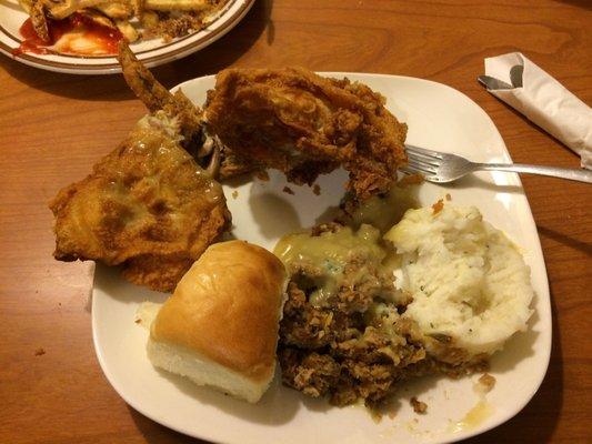 Broasted Chicken (All You Can Eat on Sundays) with a roll, stuffing, mashed potatoes with gravy, and cranberry sauce.