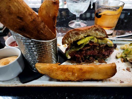 Brasstown Dry Aged Burger.  Blackened Cheshire bacon, sage derby, onion jam, homemade pickles,cracked pepper aioli and hand cut season fries