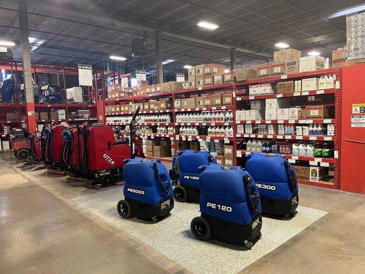 Row of floor scrubbers in front of shelves with janitorial supplies at Jon-Don Denver