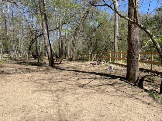 Firepit, picnic table on site next to river fence.