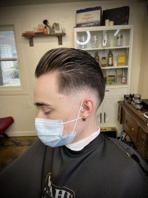 Mid bald fade with a slick back style