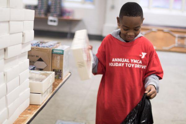 Young volunteer filling requests for re-registered families picking up toys at the Annual YMCA Holiday Toy Drive.