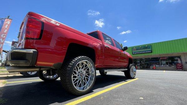 Chevy truck with 22" Chrome Wheels and All Terrain Tires.