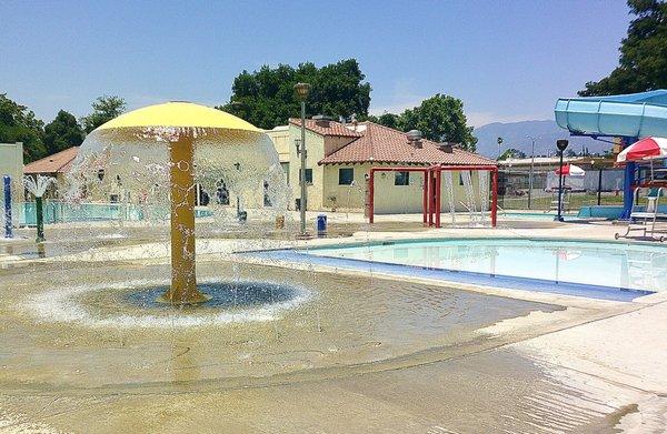 The children's wading pool at Perris Hill Park Swim Center and Water Park is surrounded by fun water features.