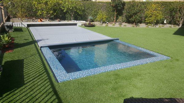 Automatic pool safety cover on a perimeter overflow pool