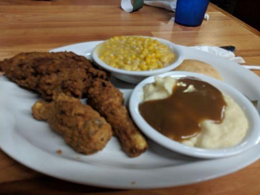 Fried chicken, mashed potatoes with brown gravy, corn