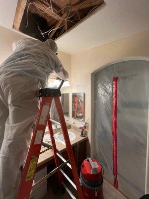 Vacuuming the dust from the drywall.