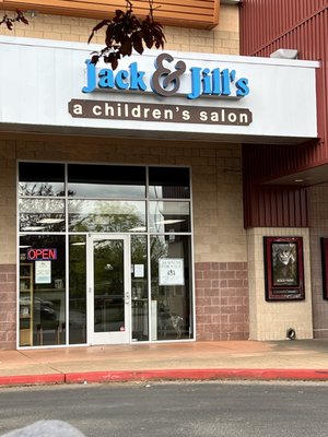 Their personal dog in the window of a kids hair cut establishment.