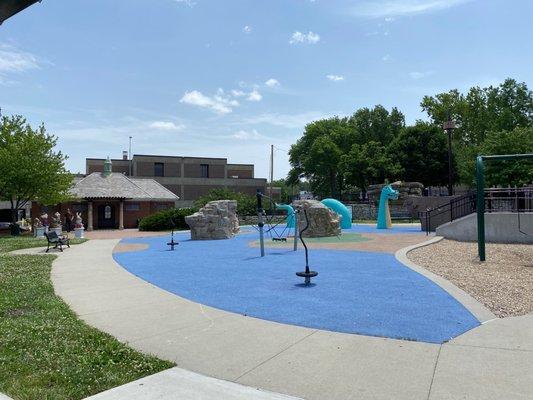 1/3 of the playground with bath house back left