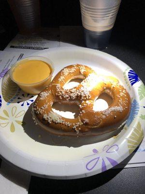 The pretzel and cheese dip on a paper plate