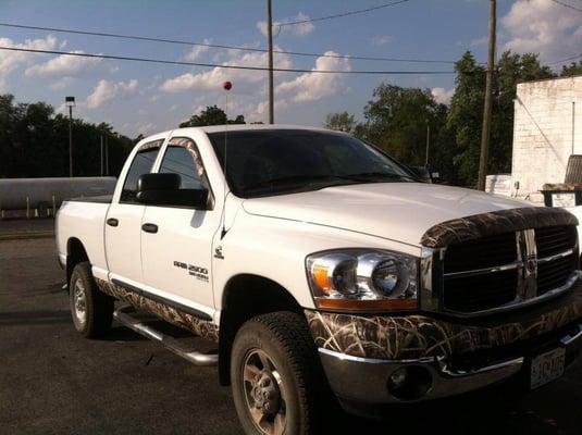 Dodge Ram with Camo Wrap on rocker panels, bumper, bug shield and vent shades.