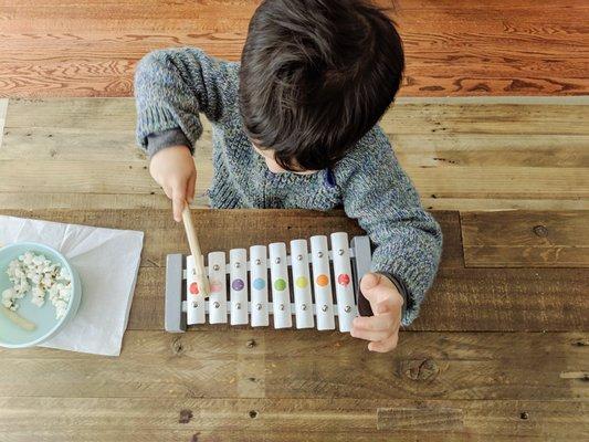 A child playing the xylophone during music therapy.