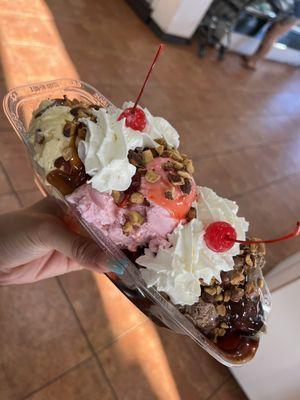 Custom banana split - rocky road w/ hot fudge, strawberry w/ strawberry topping, butter pecan w/ hot caramel topped w/ nuts + whipped cream