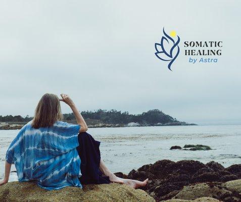 A seated woman looking at the ocean