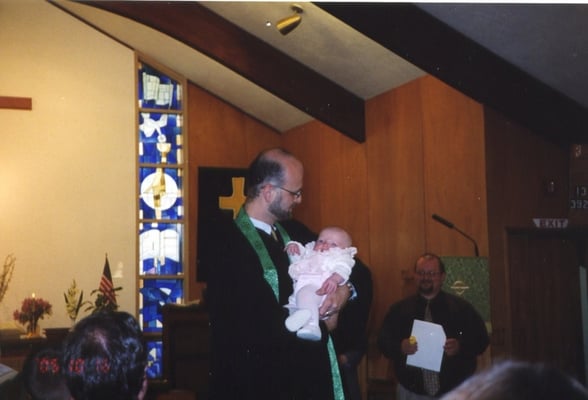 That's our pastor performing a baptism.  We take nurturing children in the faith seriously.