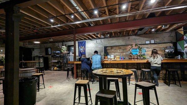 View of the space - bar, tables, merch shelf. The wood helps warm the space from all the concrete.