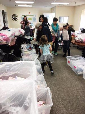 Separating girls summer clothes by size.