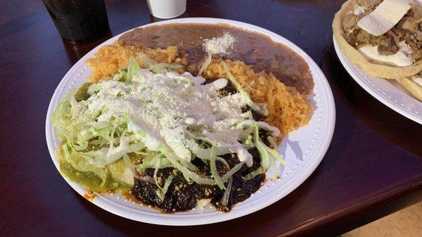 Dos salsas enchiladas de pollo (chicken enchiladas with salsa verde and rojo), arroz (rice), and frijoles pintos (pinto beans)