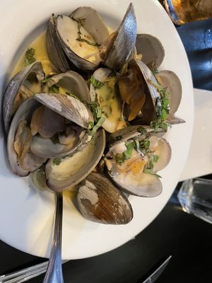 A dozen clams on top of linguini with white clam sauce