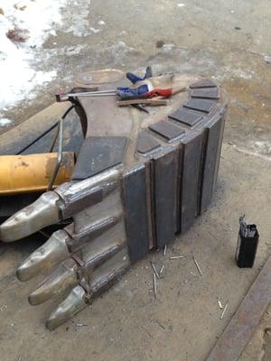 Excavator bucket repair, rebuilding, hard-facing and modification