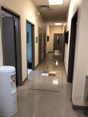 Hallway with water fountain and a restroom leading to the patient care rooms.