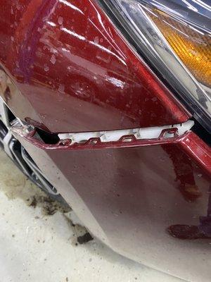 Bumper dislodged from car with snow packed behind it