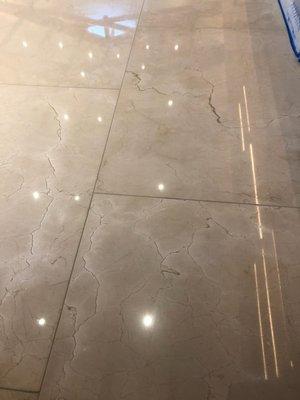 Marble polished floor shows ceiling lights shining in it.