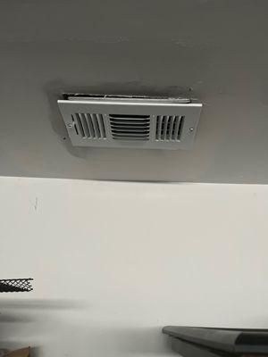 The vent is not flush with the drywall because it hangs too low.