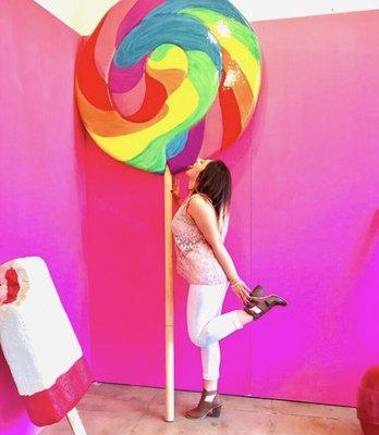 Guest  pretending to lick a giant lollipop at POP LA!