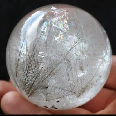 Colors of the rainbow combined with the rutiles in this quartz sphere tell many fascinating stories and encourage insightful intuition.