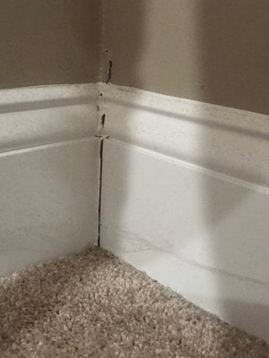 Bedroom baseboard with fairly large crack in wall