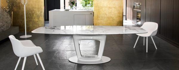 Orbital table, sculptural design opens to seat 10, shown in white base with ceramic marble