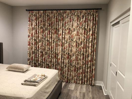 Beautiful flowered fabric curtain on metal rod.